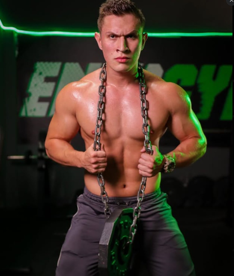 Entrenador de ENERGYM posando con cadena de entrenamiento